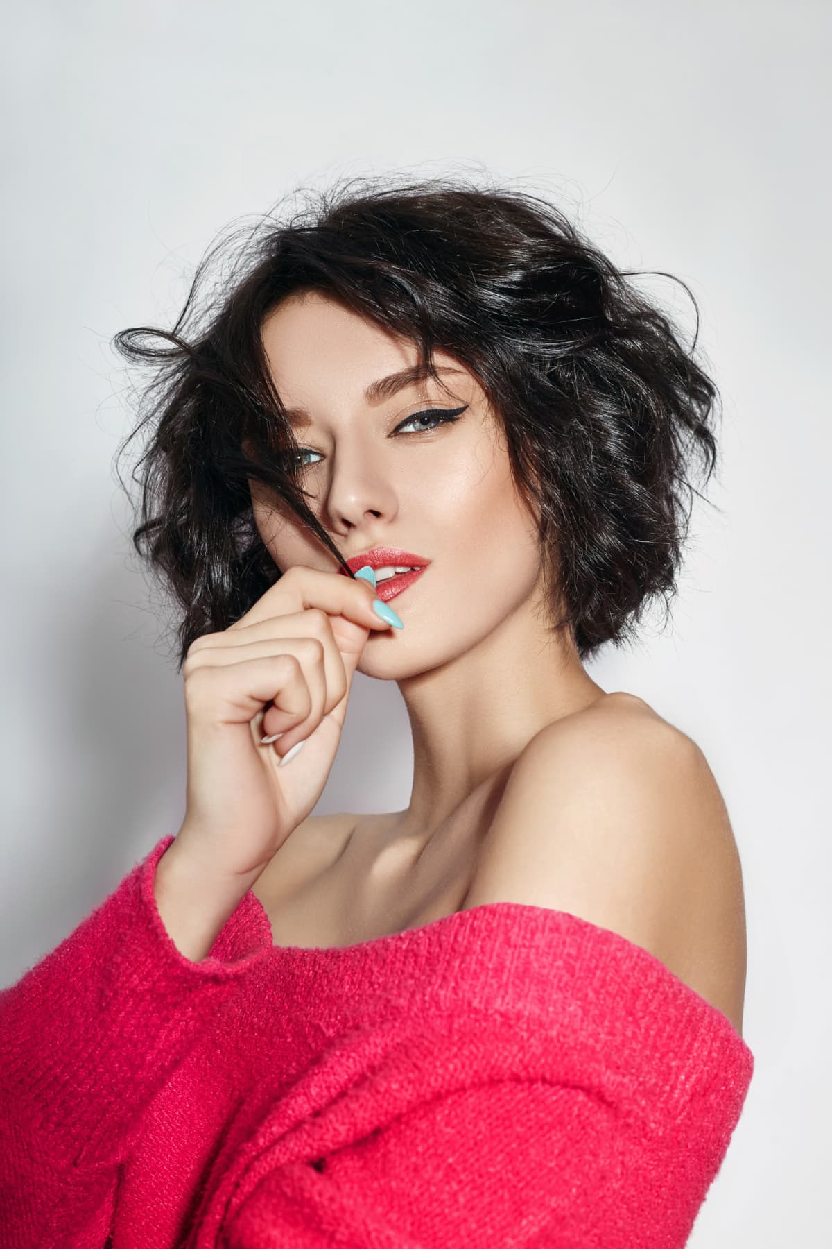 woman with short hair. Girl posing in a red sweater on a white background. Perfect clean skin, sexy Nude body of brunette woman. Skin rejuvenation and hydration