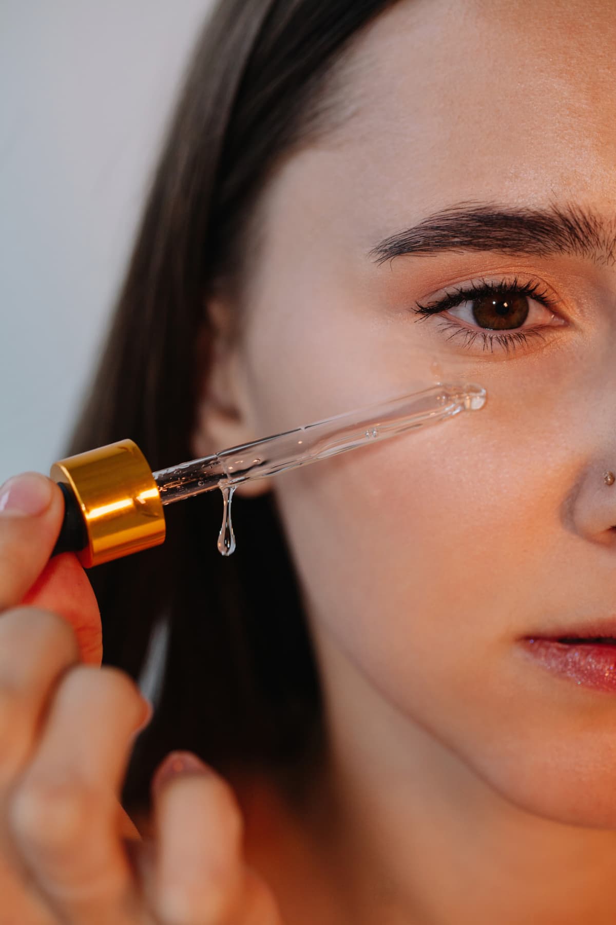 Close-up of a woman applying serum to her face