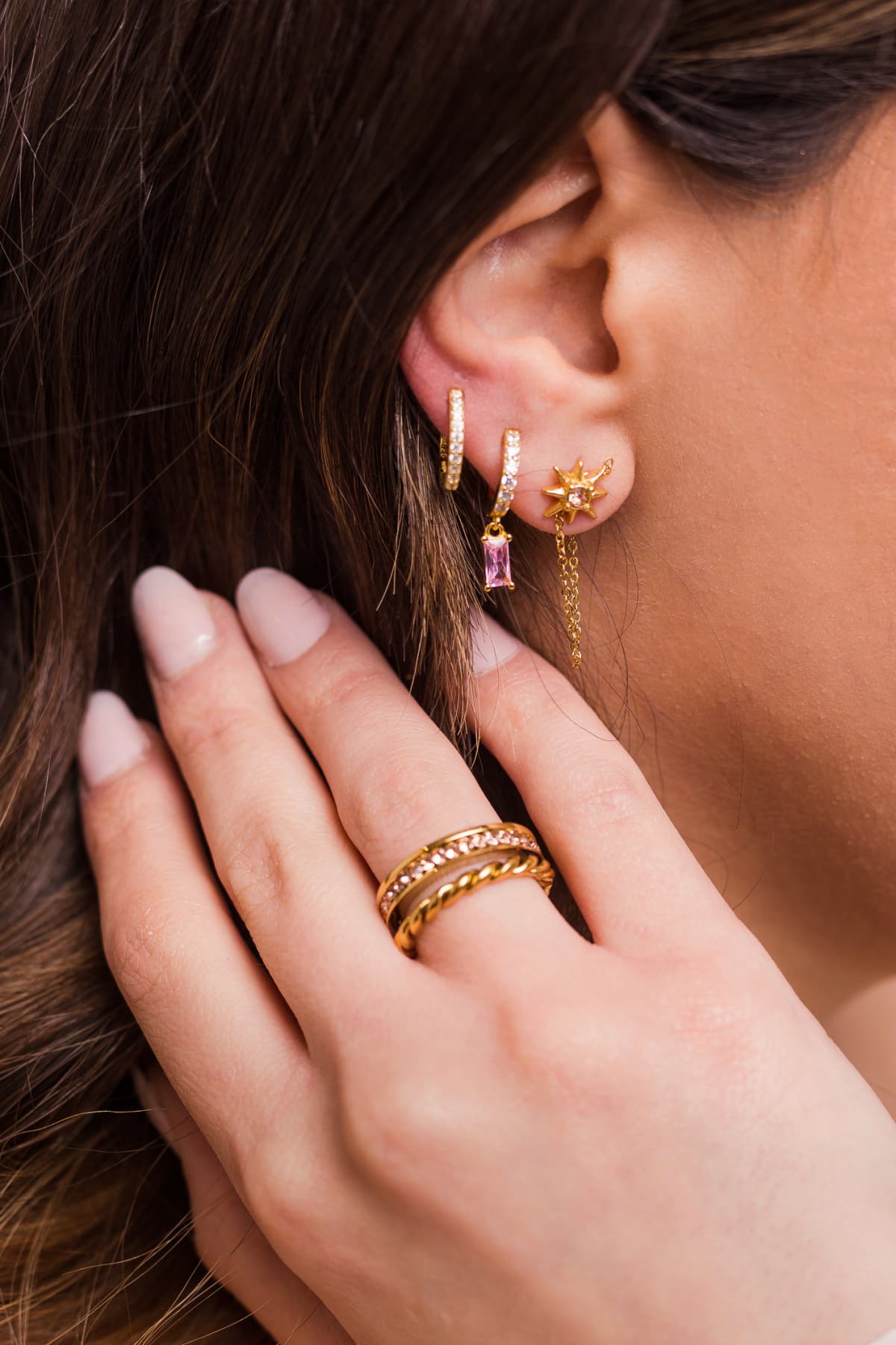 Close up of a woman wearing three an earring stack in her three ear piercings
