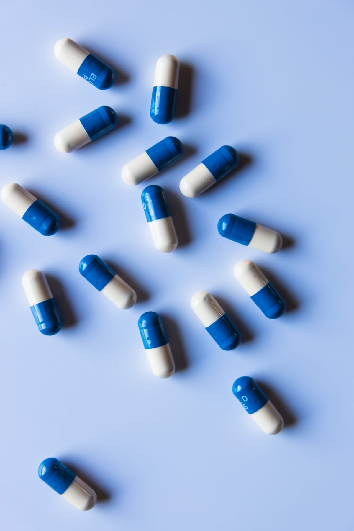 White and blue pills scattered on a surface