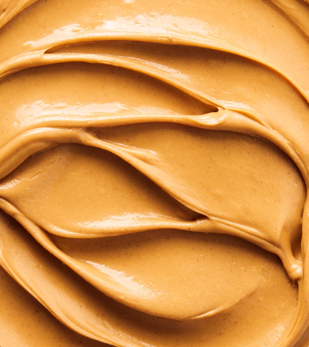 Close-up shot of creamy peanut butter swirls. decadent swirls filling the whole frame.