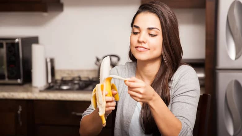 A woman peeling a banana
