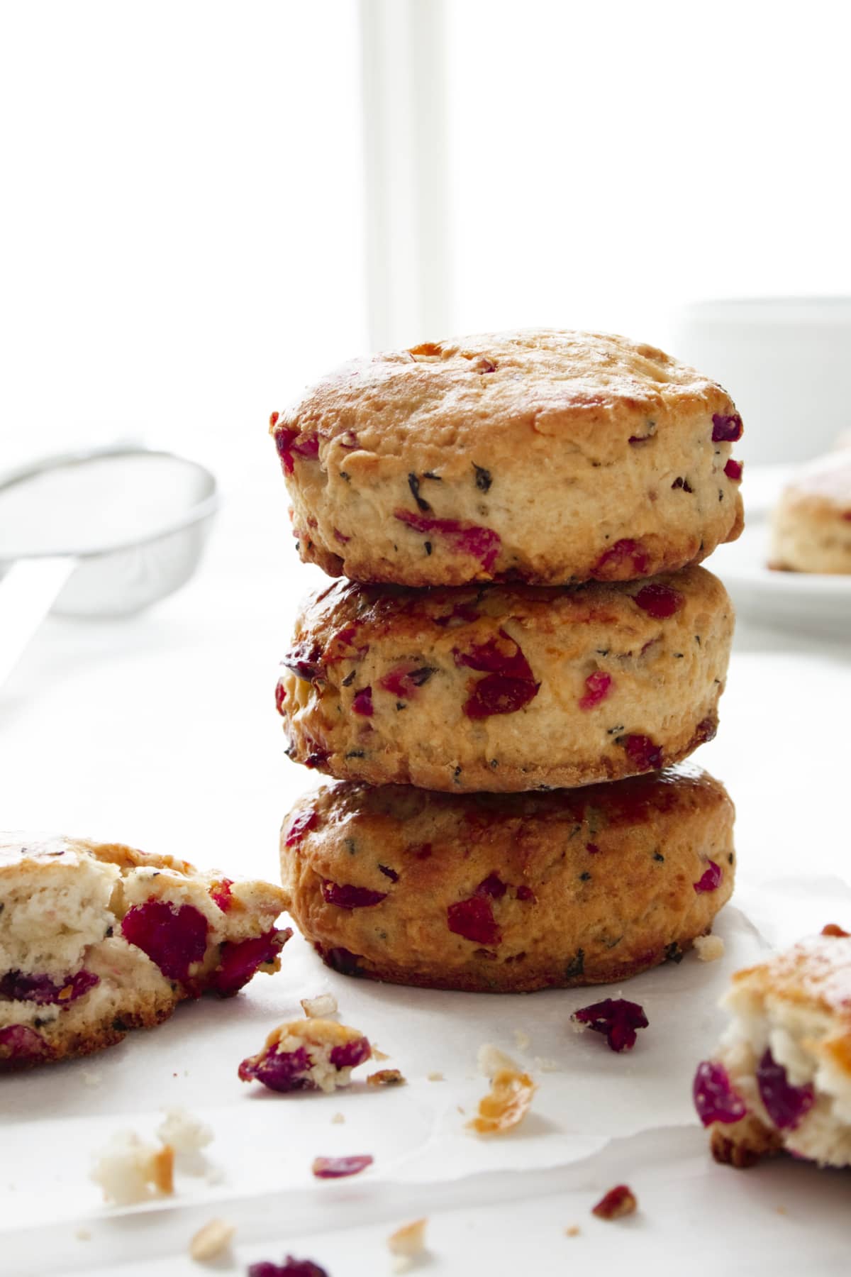 Freshly baked homemade cranberry scones in a stack on baking parchment.
