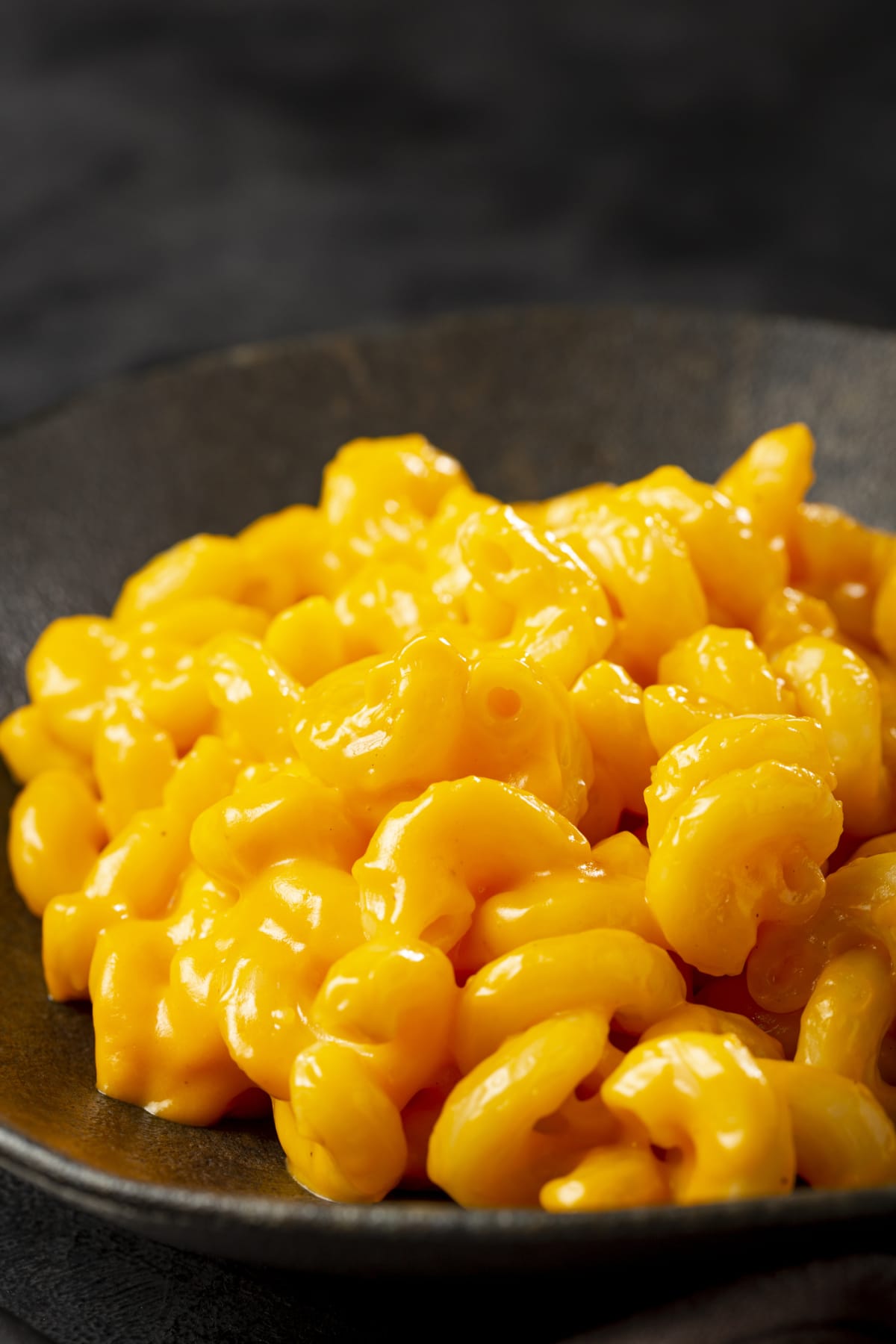 close up photo of a spoon picking up macaroni and cheese