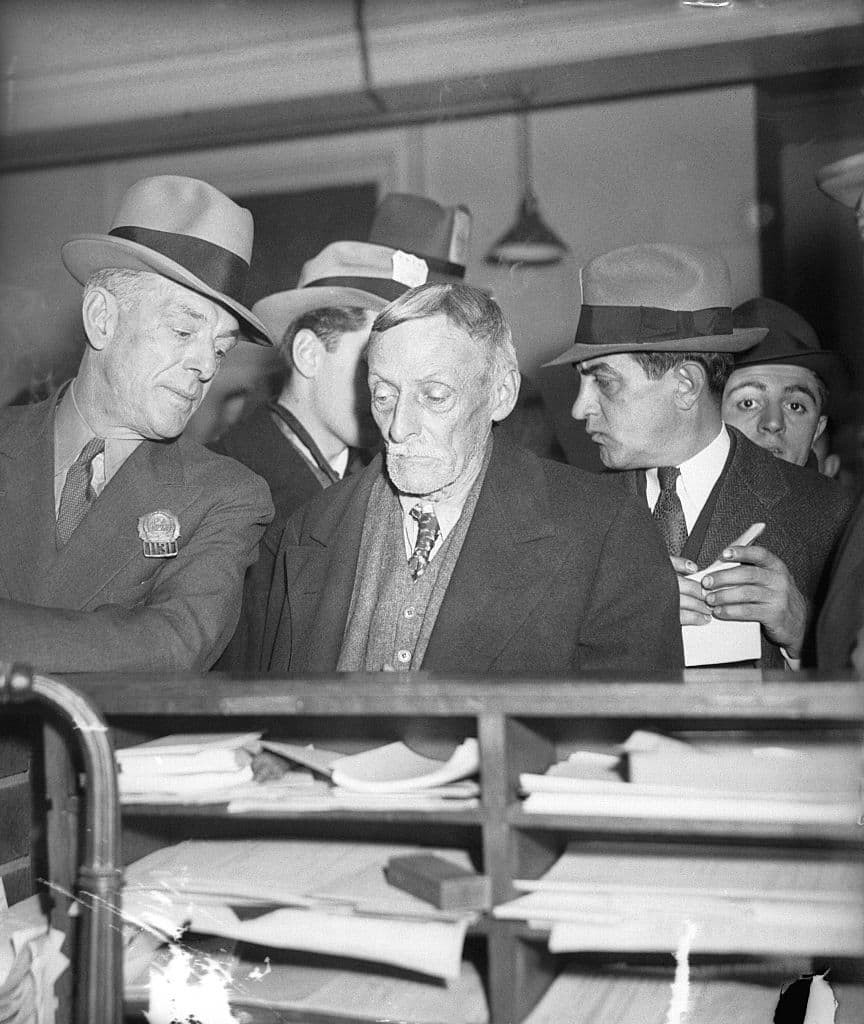 Child killer and cannibal Albert Fish is led into homicide court by detective William King.