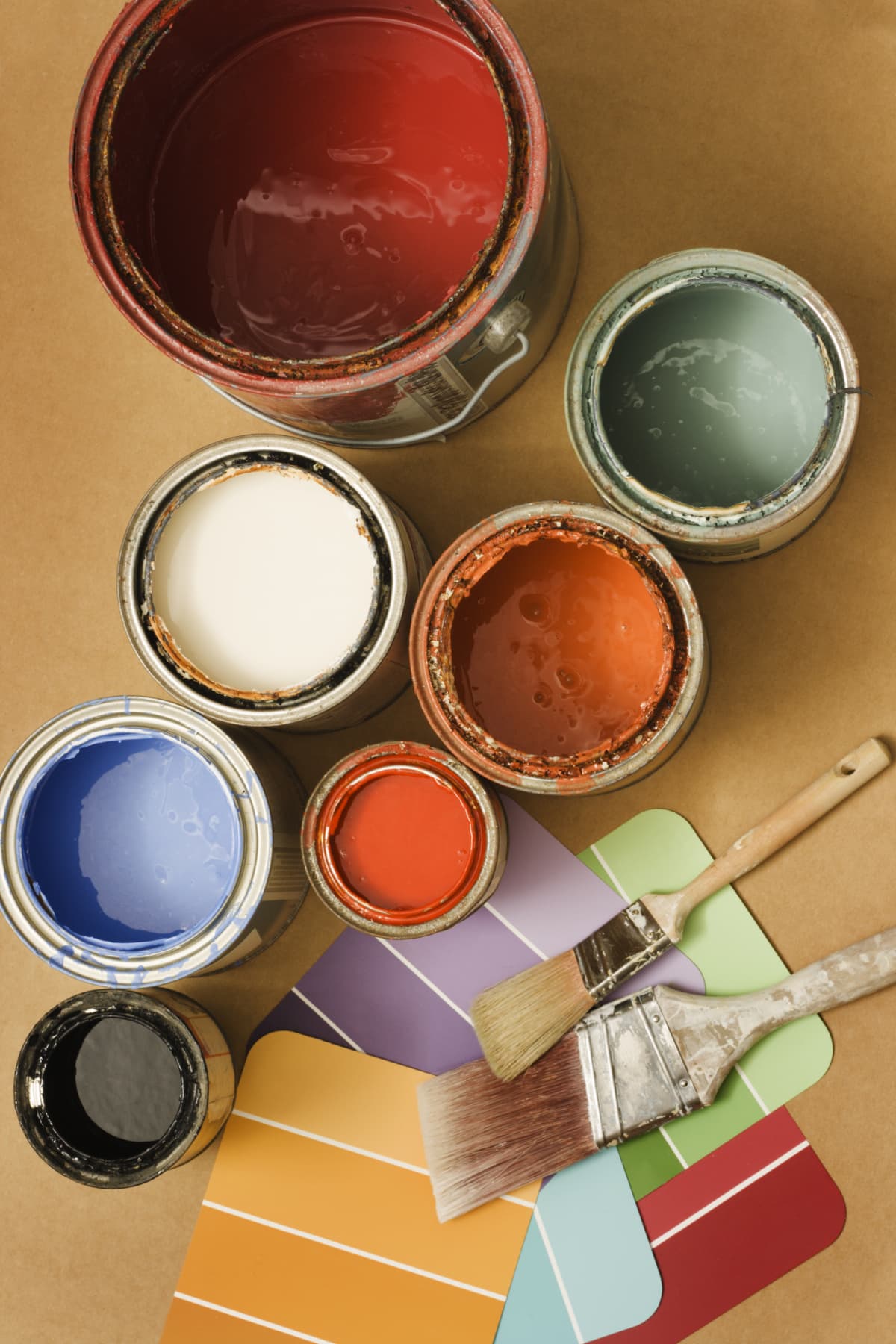 Open paint cans, paintbrushes and color swatches in preparation for home decorating and home improvement projects