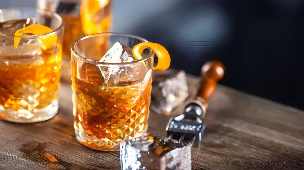 Old Fashioned in a glass with ice and garnished with an orange peel
