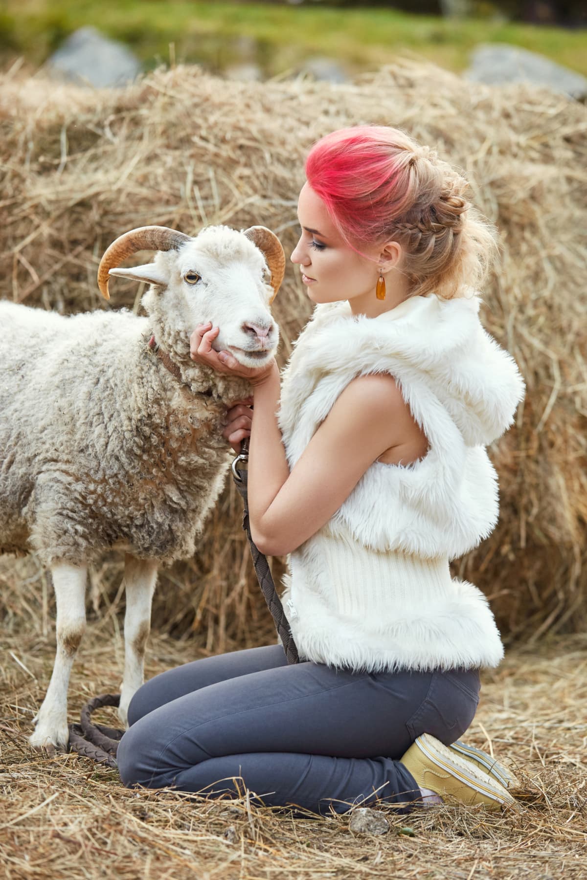 Woman hugs a ram in a field