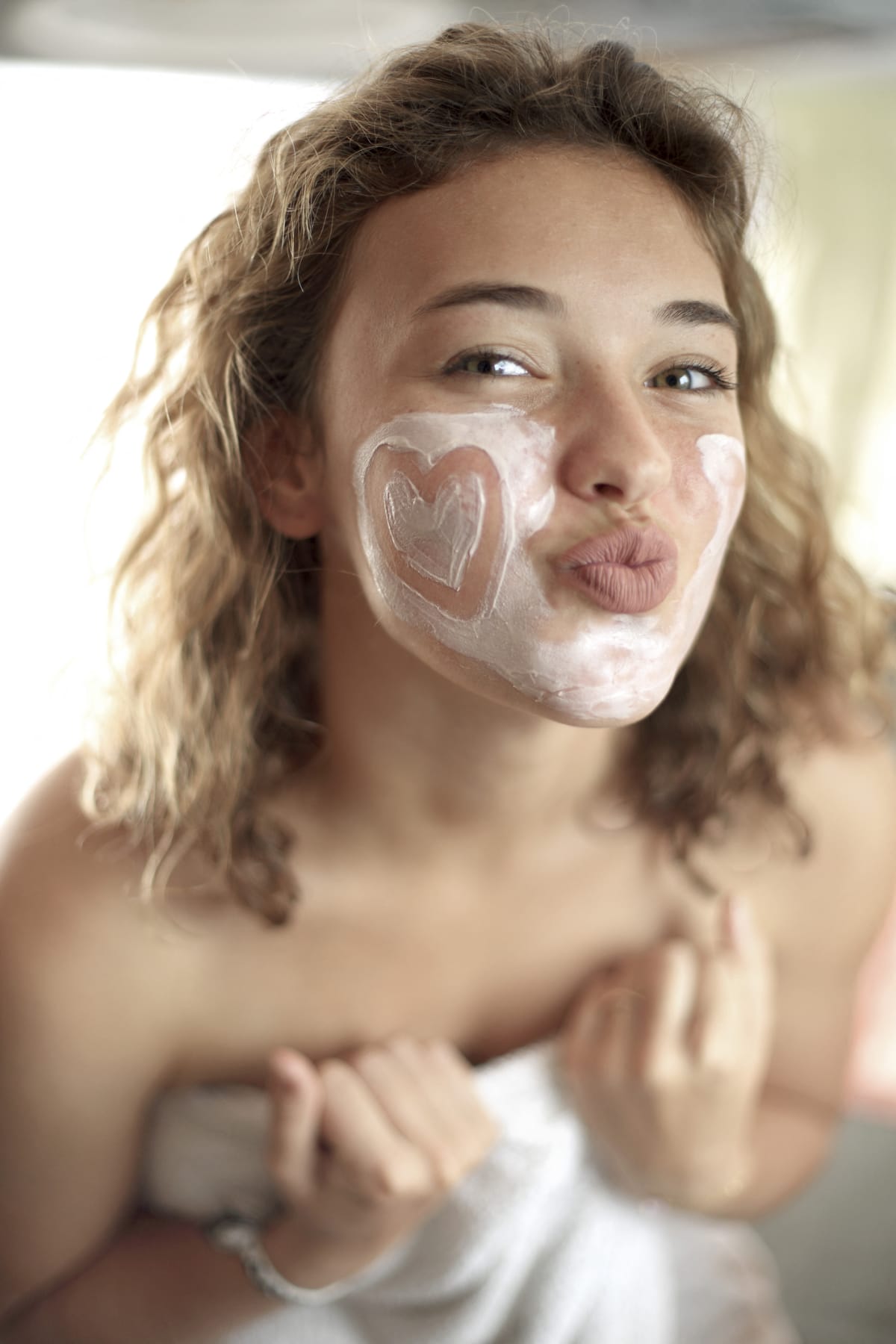 Woman applying cream on her face.