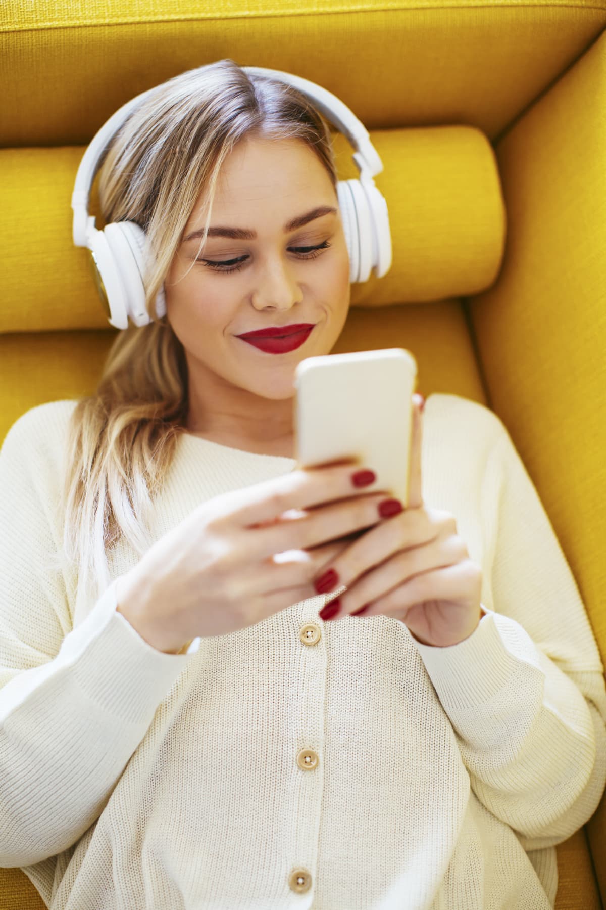 Woman listening to green noise on her headphones smiles at phone