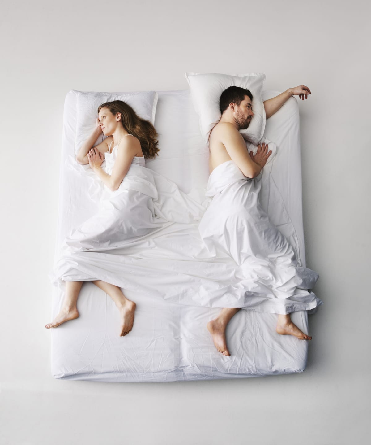 Adult couple laying in bed, elevated view