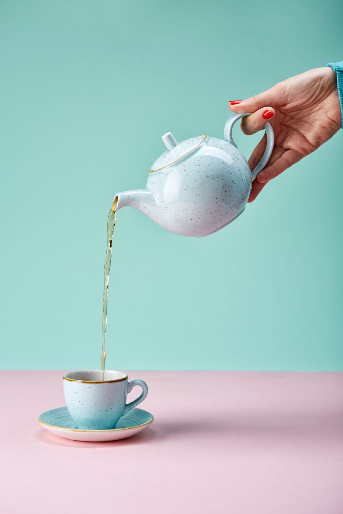 A person pouring tea out of a teapot