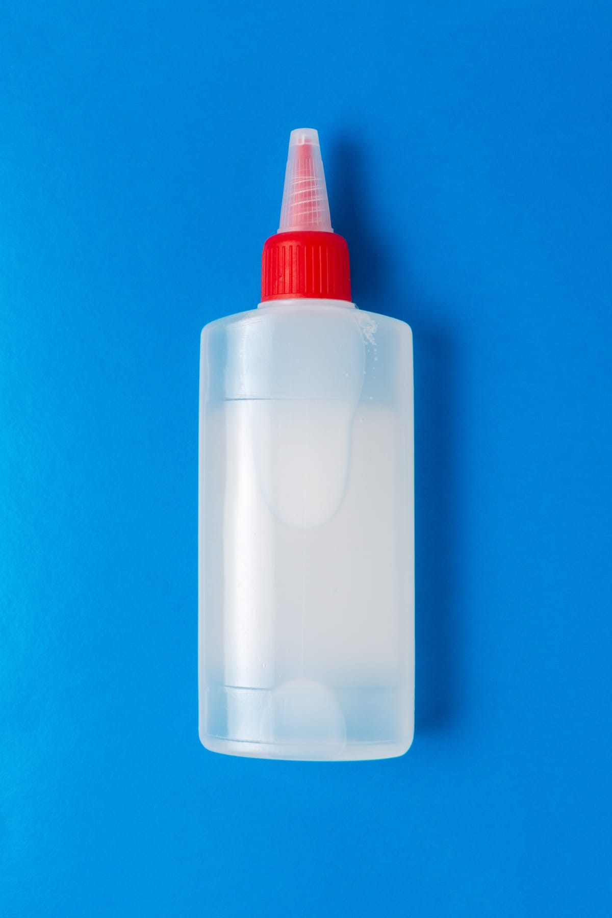 A bottle of glue isolated on a blue background