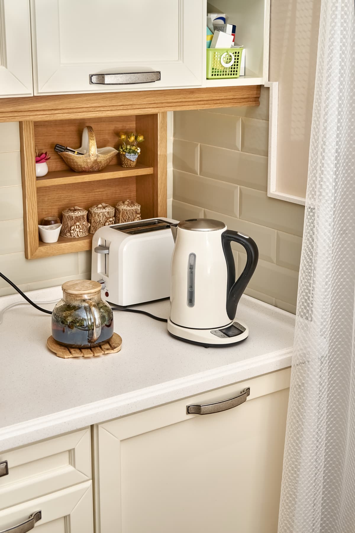 Kitchen counter corner with cabinets, a toaster, and an electric kettle