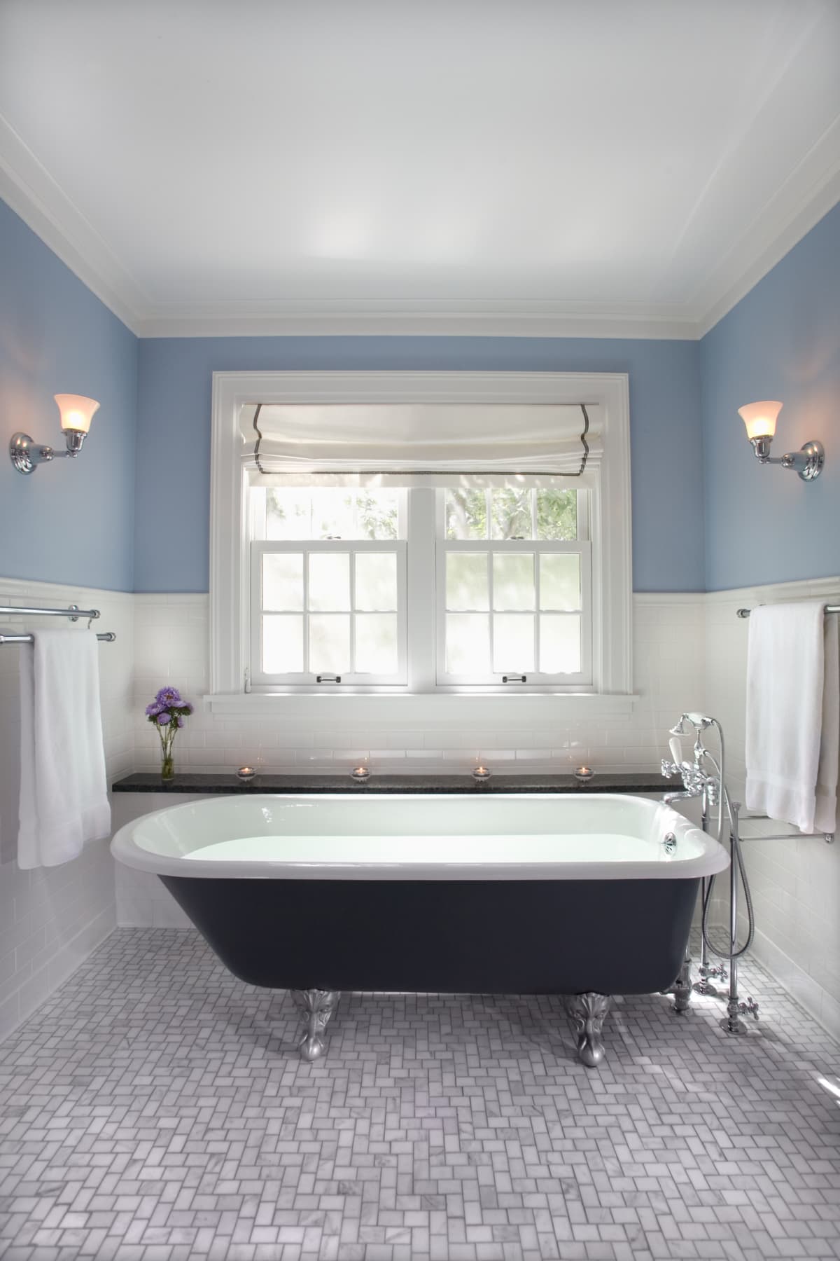 A bathroom with blue and white walls with a raised pedestal tub