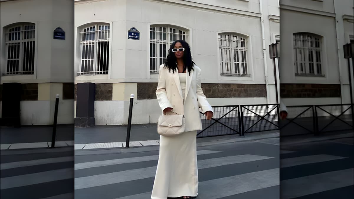 A woman wears an all white ensembles with matching purse