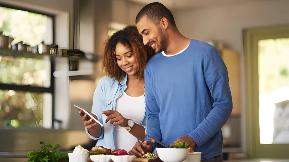 A couple in the kitchen looking at a phone together