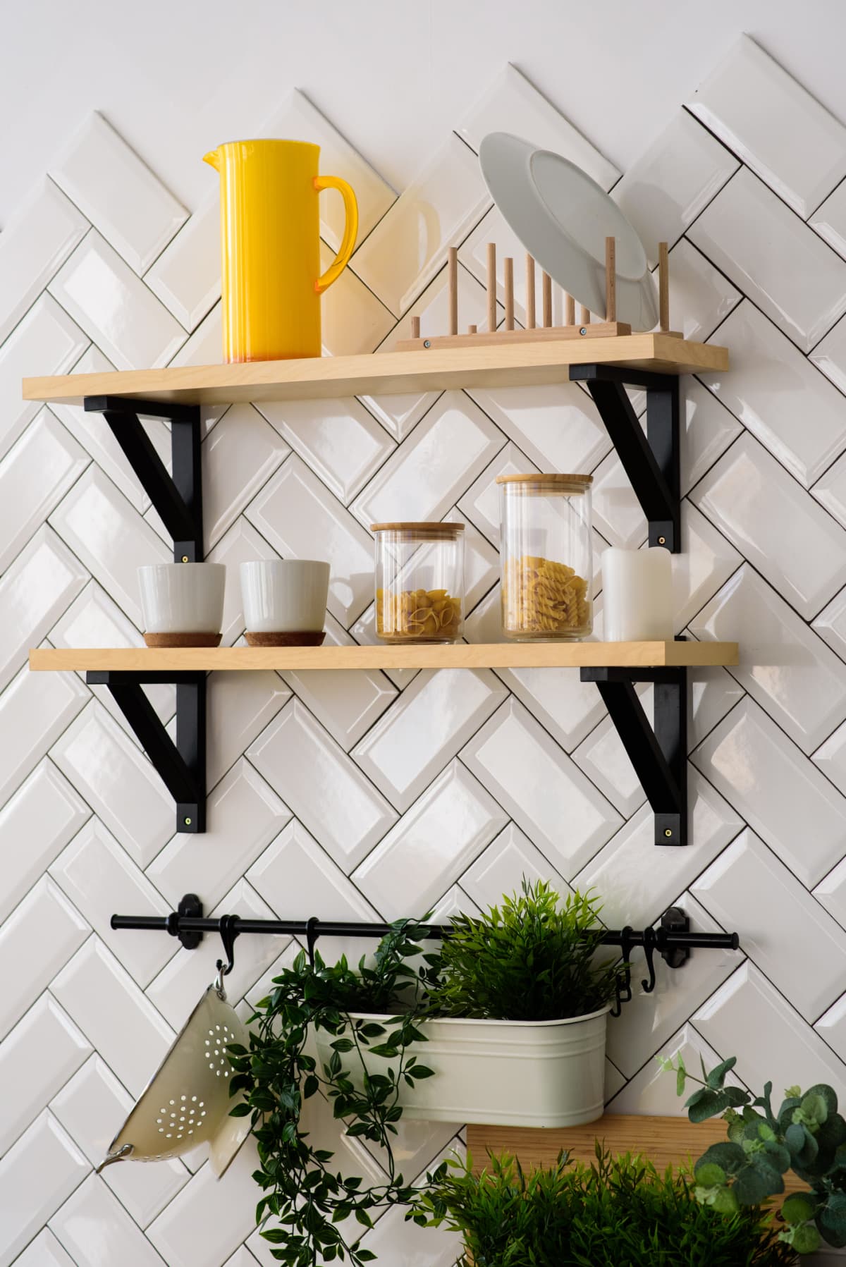 A kitchen wall with diagonal white tiles