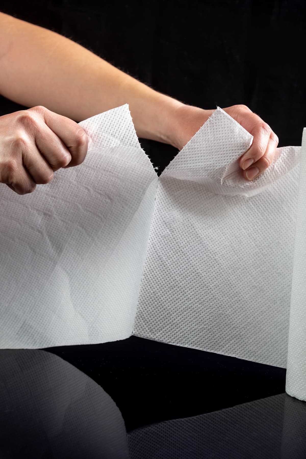 person tearing a sheet of paper towel