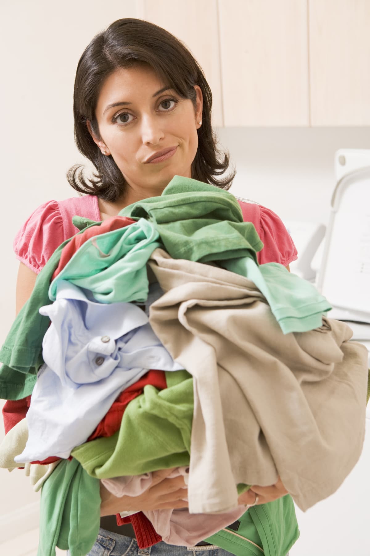 Woman holding a pile of laundry.