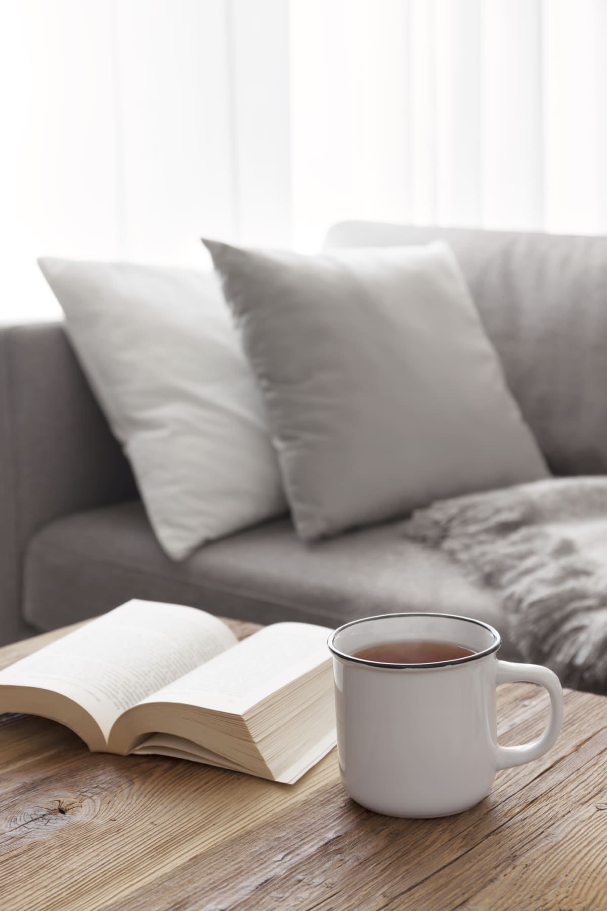 Cozy afternoon reading on the sofa with a steaming cup of tea