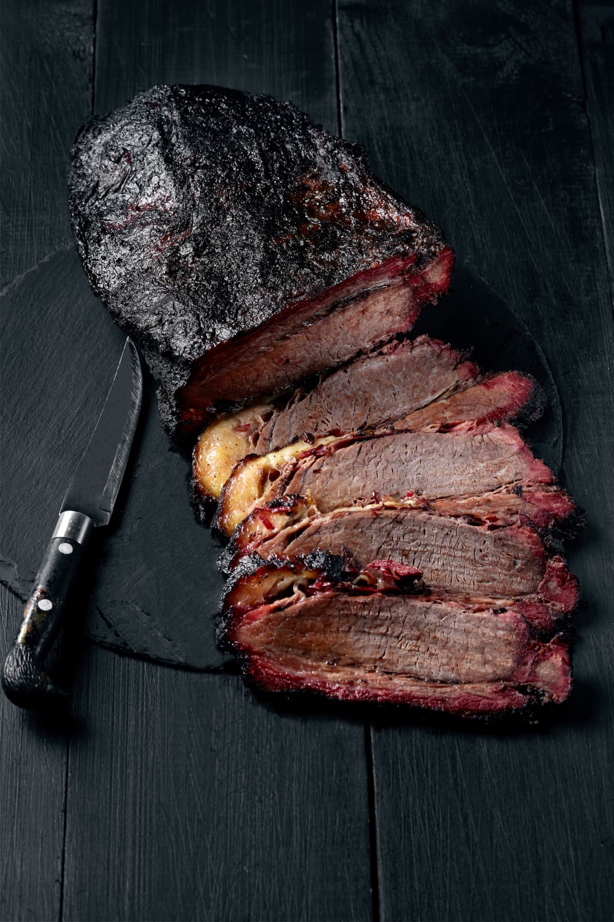 Fresh Brisket BBQ beef sliced for serving against a dark background. Generous accommodation for copy space. American style