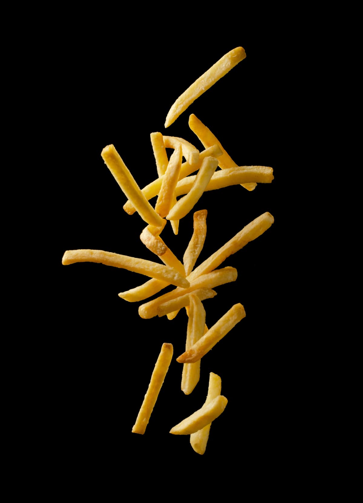 Fries falling against black background