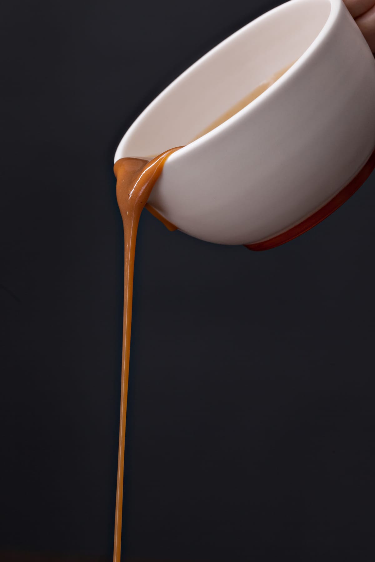 A bowl of gravy being poured