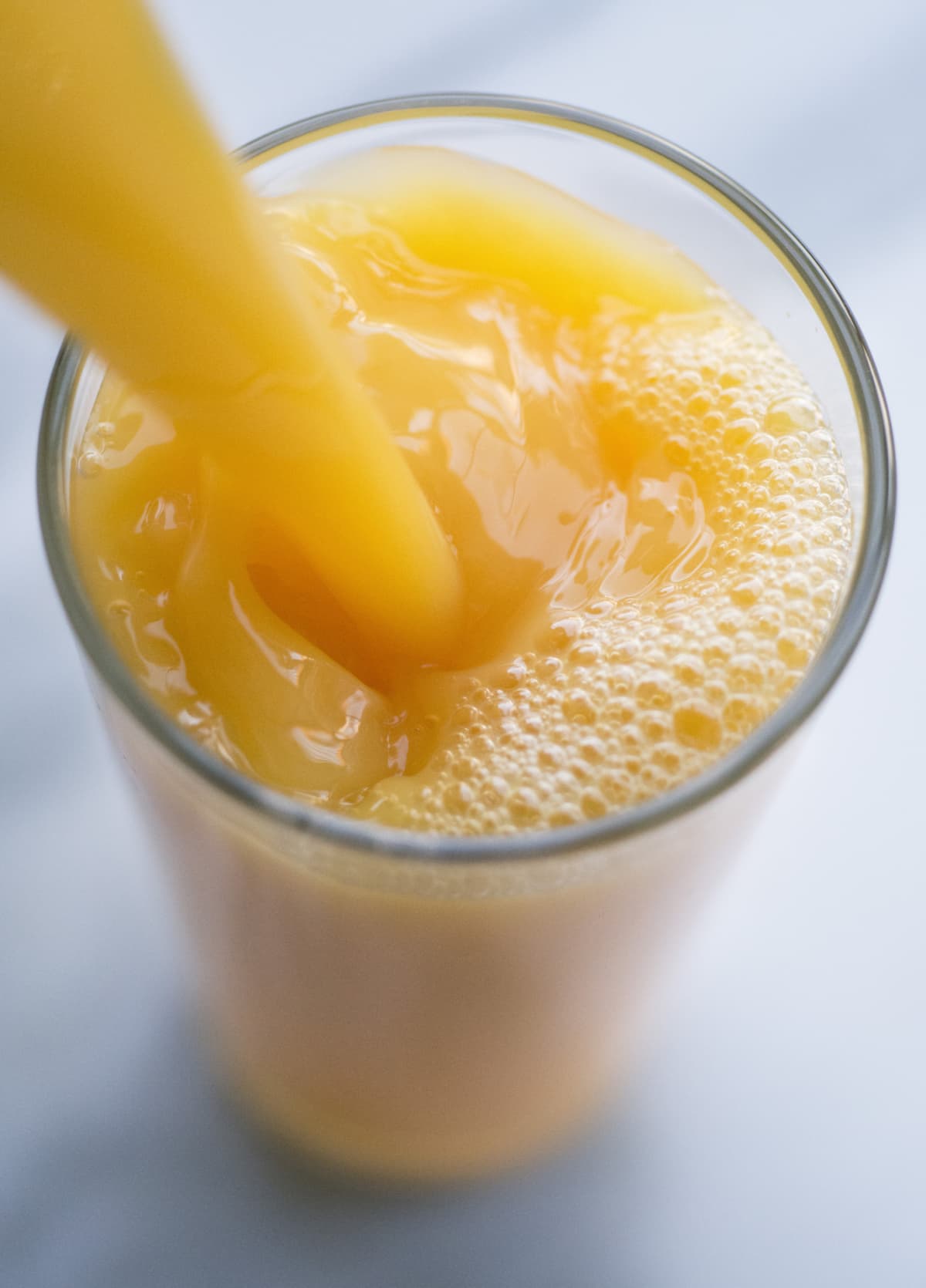 Orange juice being poured into a glass