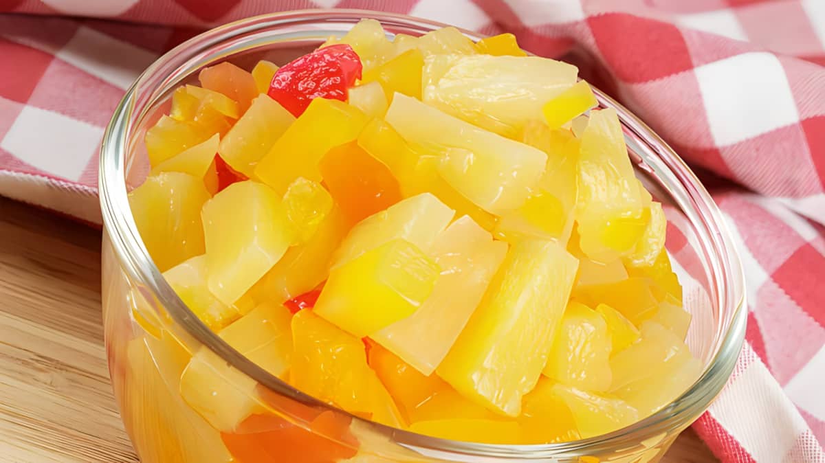 A clear glass bowl of canned fruit salad