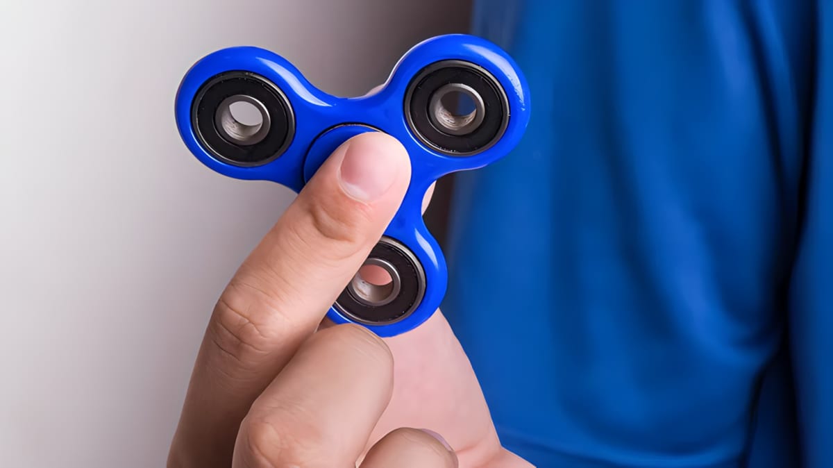 Hand holding a blue fidget spinner