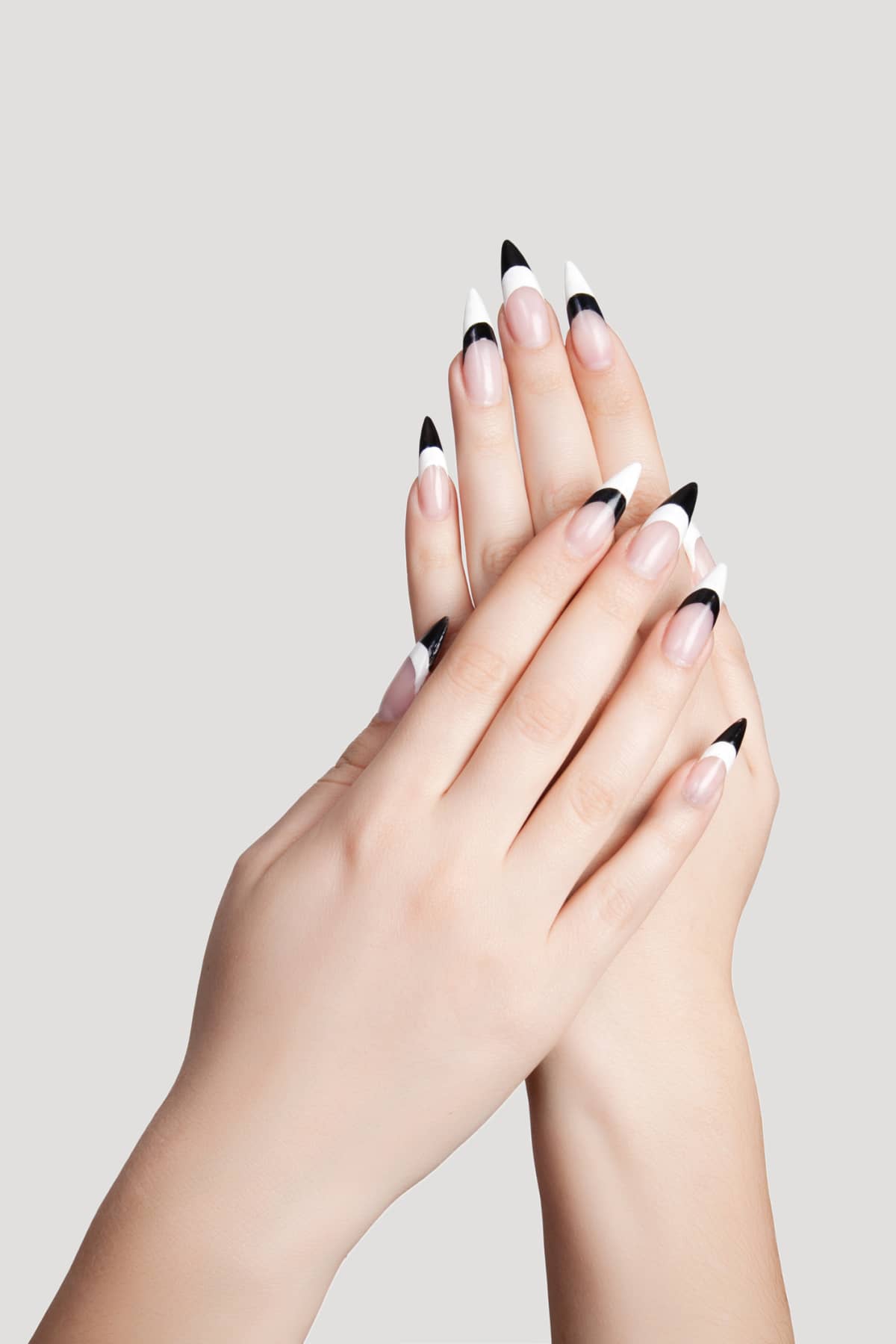 Two hands with beautiful nails sharp shape on gray background