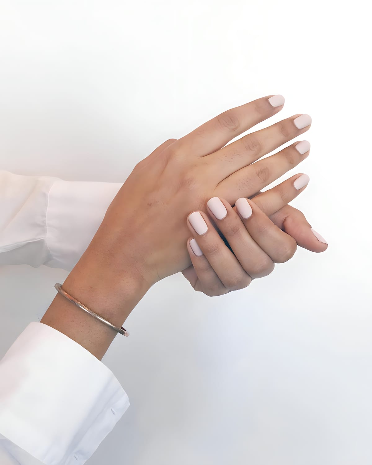 Female two hands with white nail polish