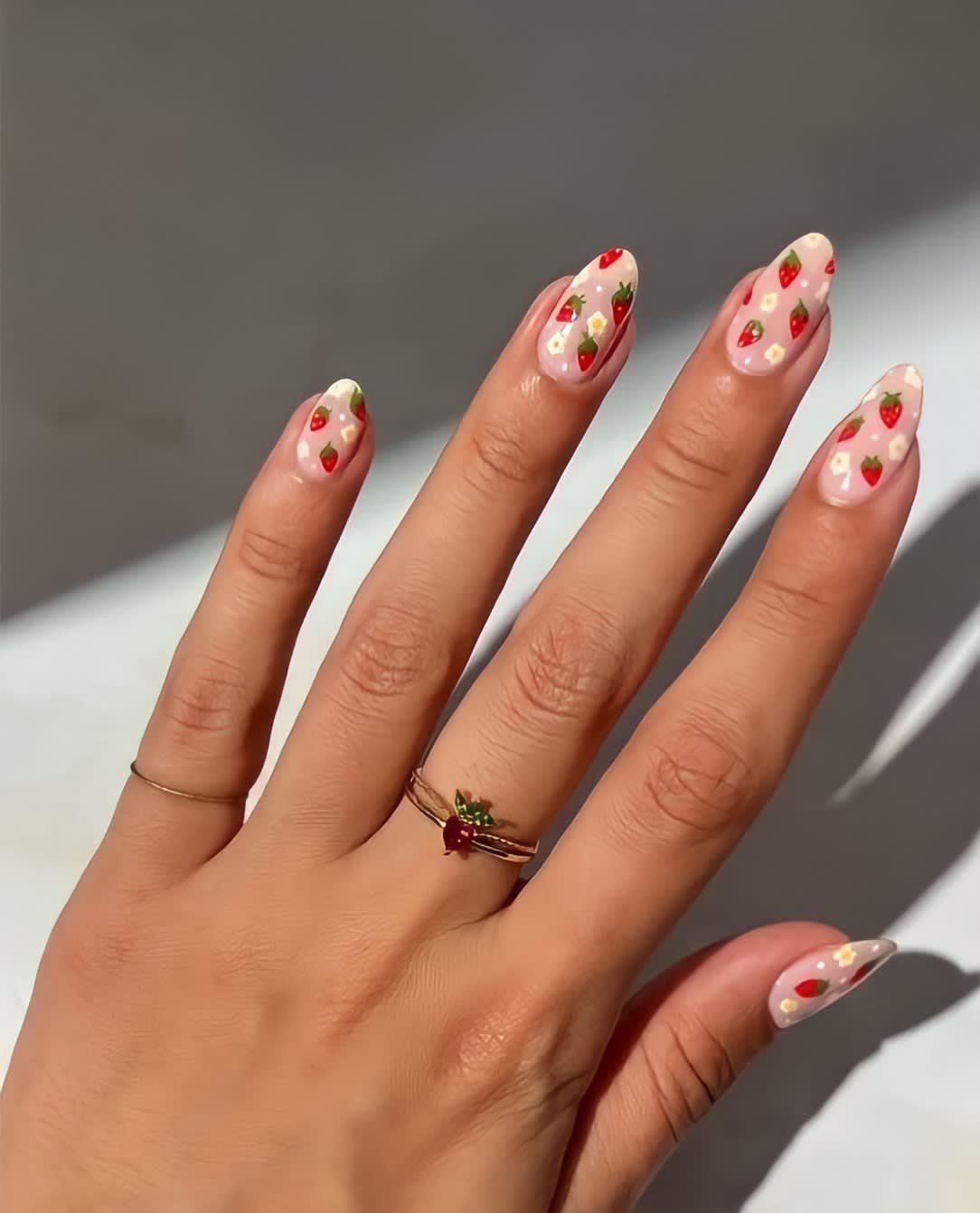 Hand with strawberry and daisy painted nails