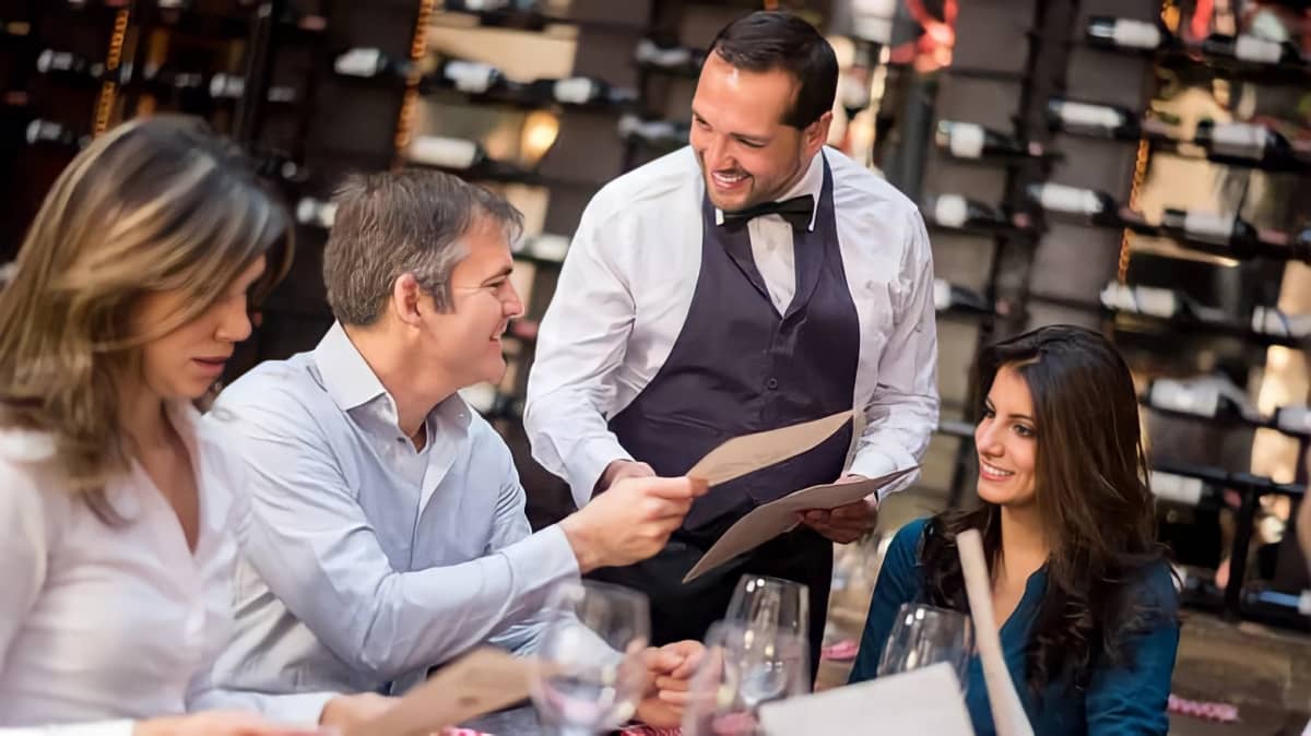 A man orders food from a waiter during a business lunch