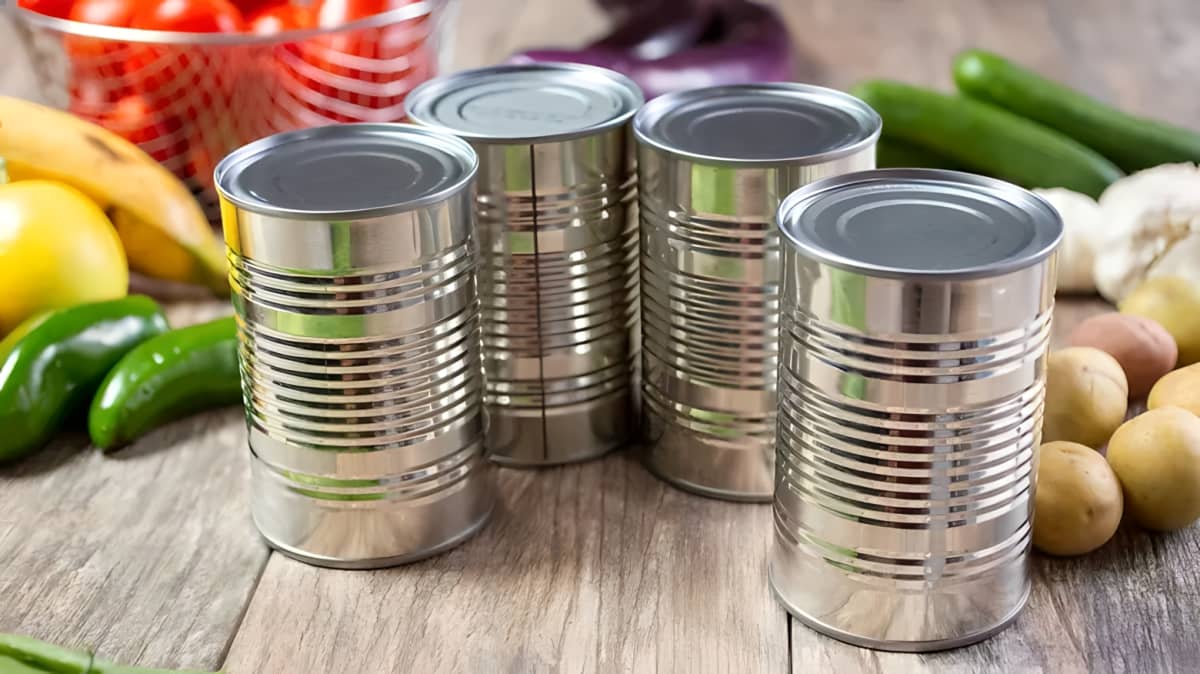 Tin cans of soup on a wooden surface