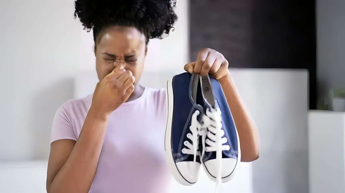 A woman holding smelly shoes