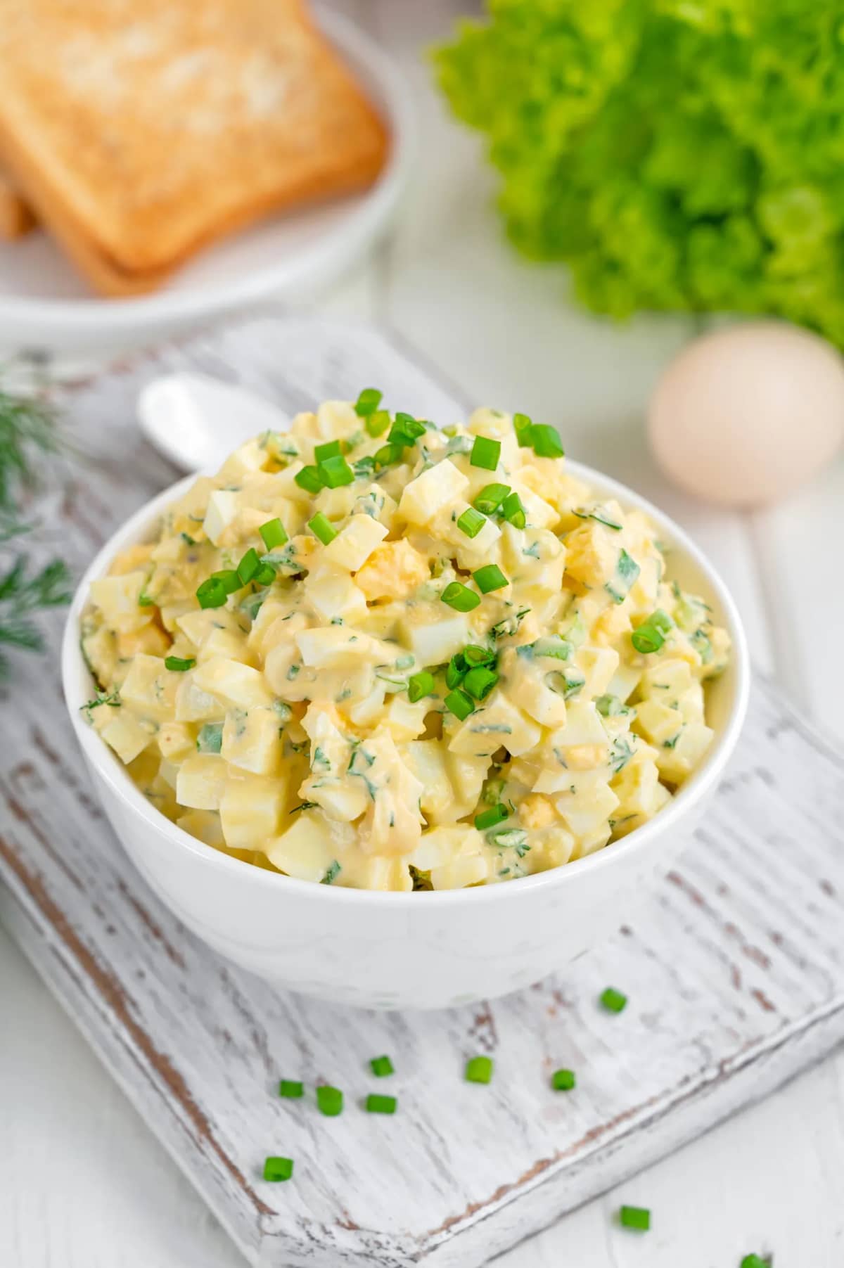 A bowl of egg salad topped with green onions