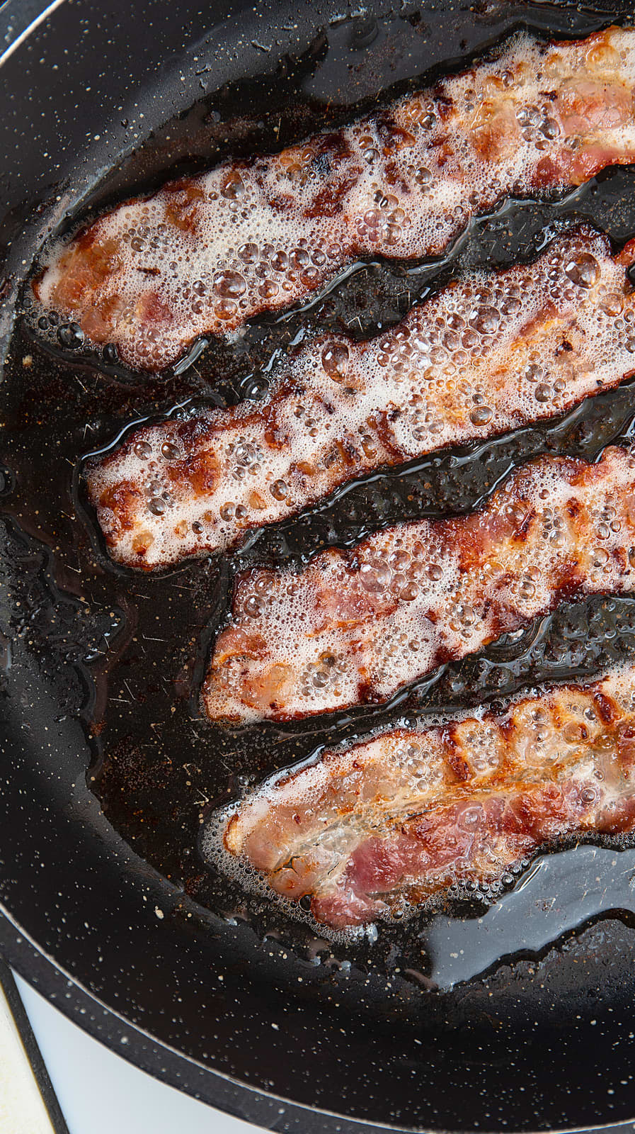 Bacon being cooked in grease