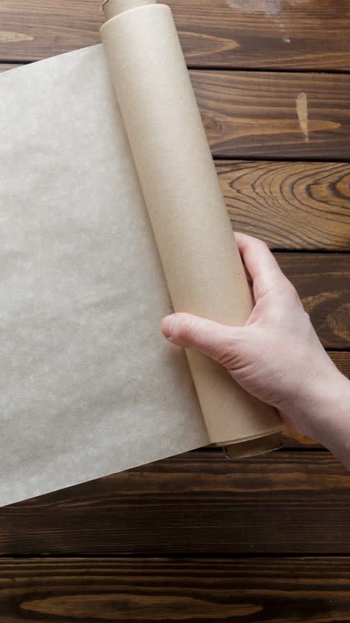 Hand holding a roll of parchment paper