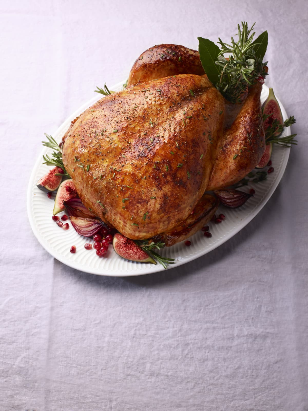 Roast turkey with rosemary, red onions, figs, and red berries