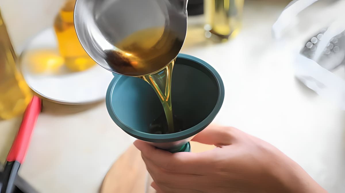 Oil being poured into a funnel.