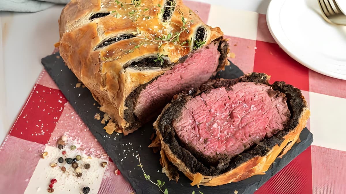 A closeup of beef Wellington on a wooden board. 