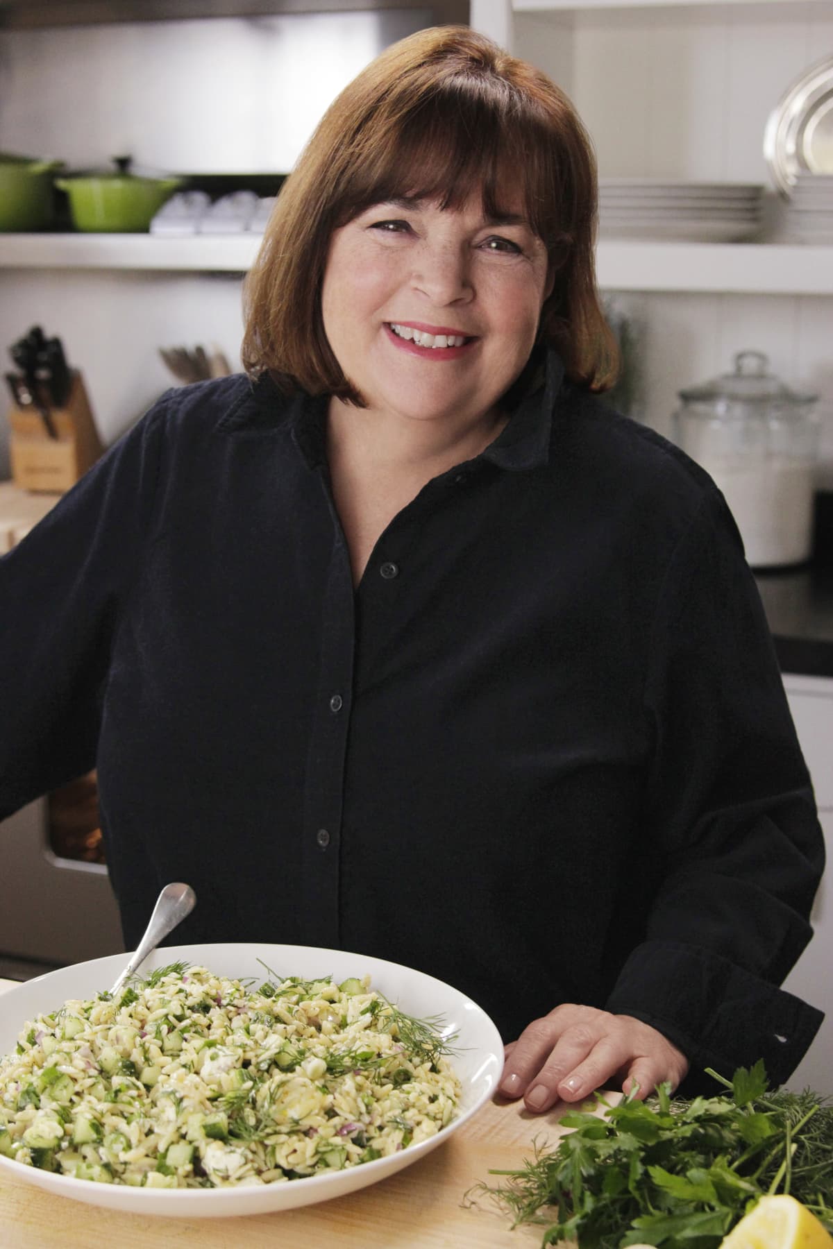 Ina Garten with a plate of food in a kitchen