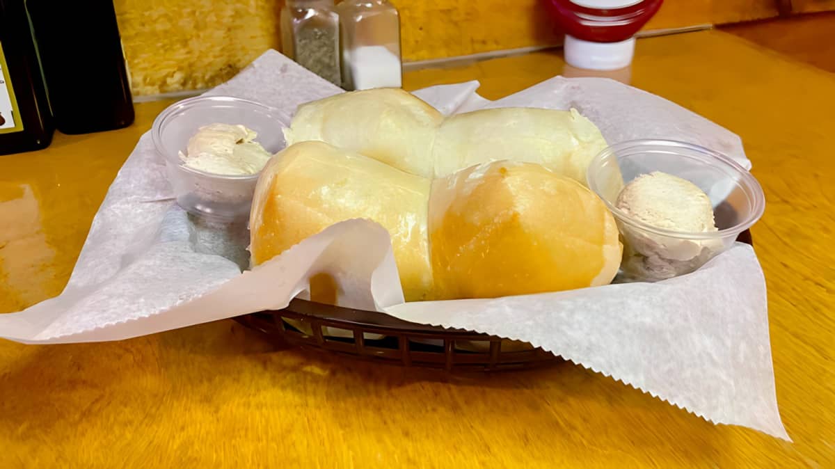 Dinner rolls in a basket with butter.