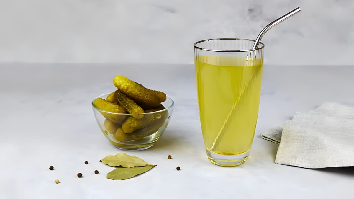 Pickle juice in a glass with straw
