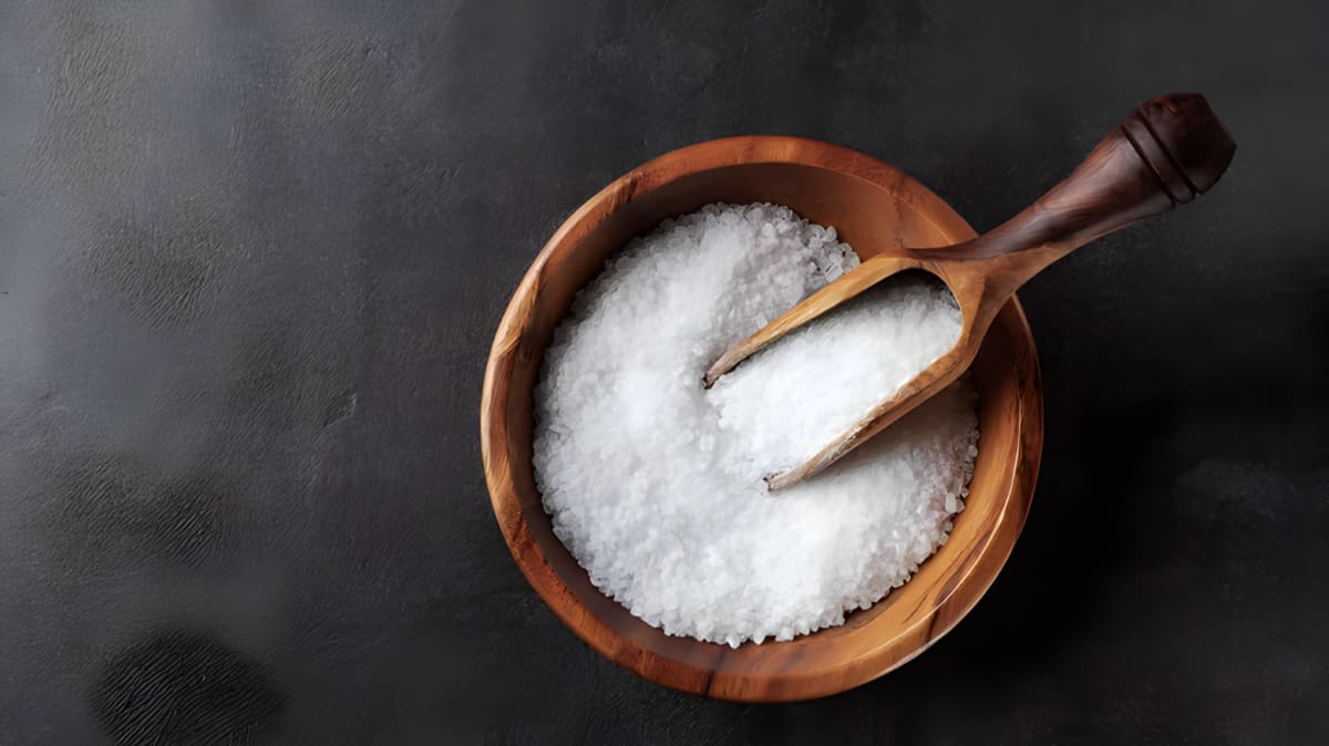 Salt in a wooden bowl with a wooden spoon