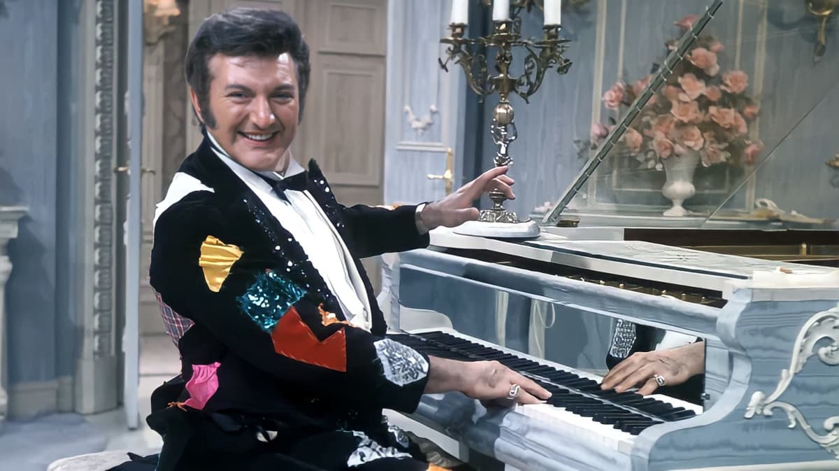 Pianist Liberace smiling on the piano