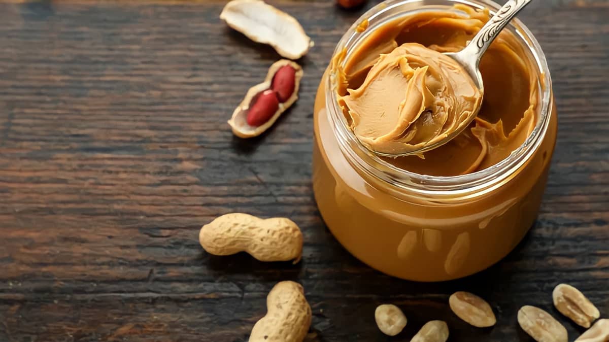 Peanut butter being spooned out of a jar.