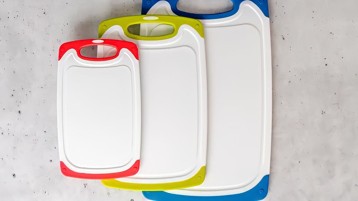 A selection of white plastic cutting boards with colored handles